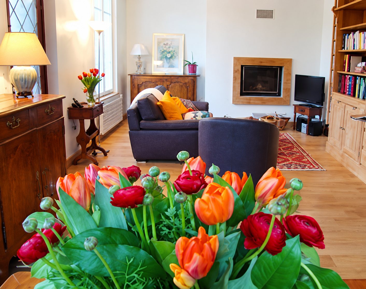 Salon lumineux avec bouquet de tulipes orange et rouges au premier plan
