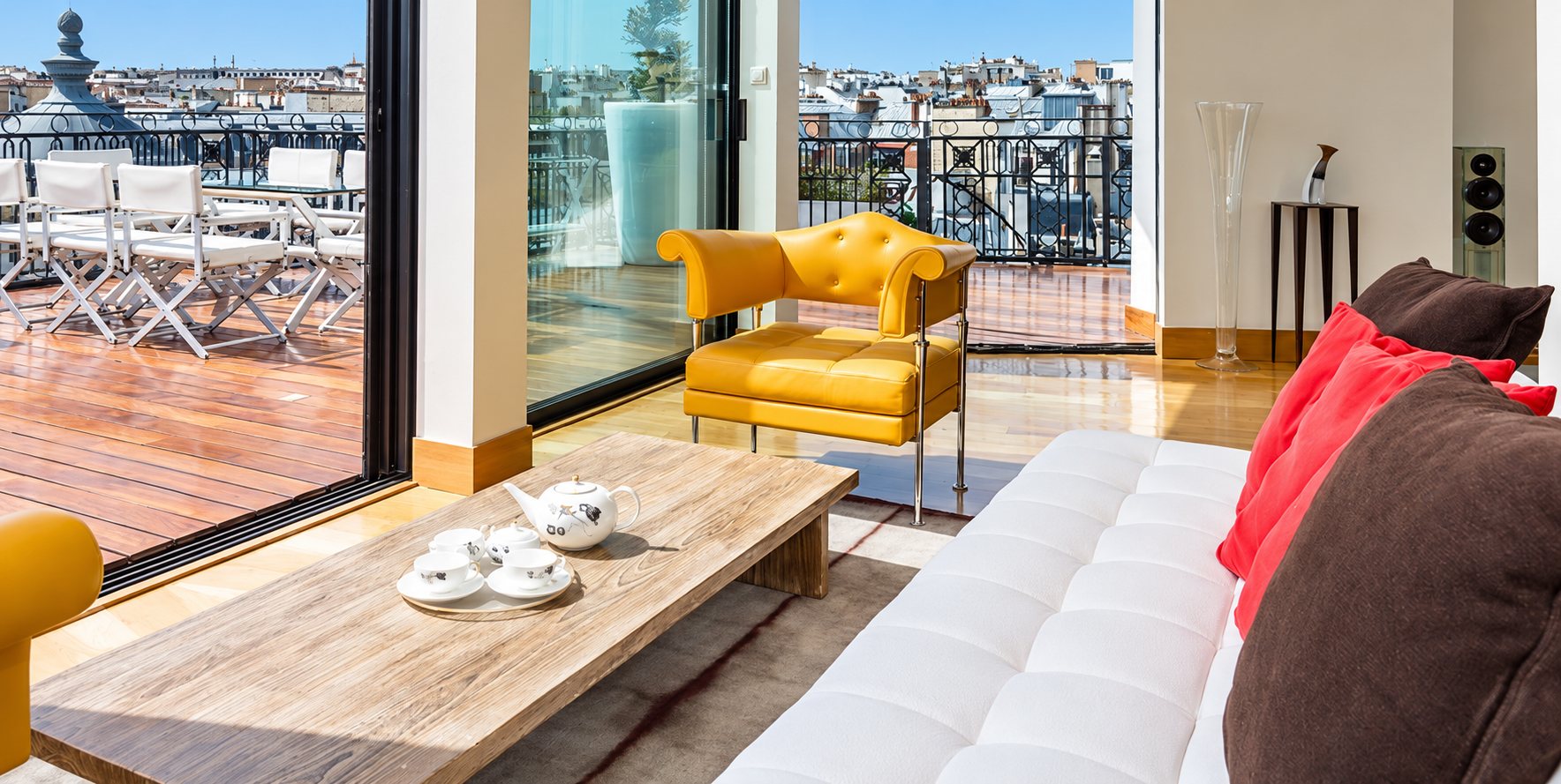 Salon lumineux avec terrasse en bois et vue sur les toits de Paris